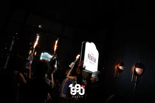 Night celebration at The Fleur Room, New York, with bottles and sparklers, hosted by 1990 Group.