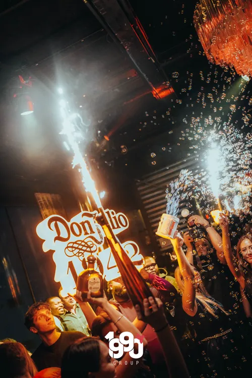 Liquor bottles and sparklers, surrounded by bubbles from a VIP service by 1990 Group in New York.