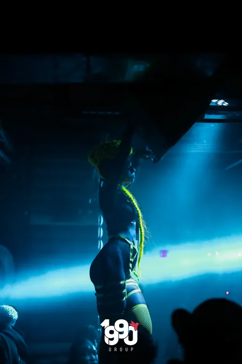 Dancer with extravagant costume illuminated at a party in New York, hosted by 1990 Group.