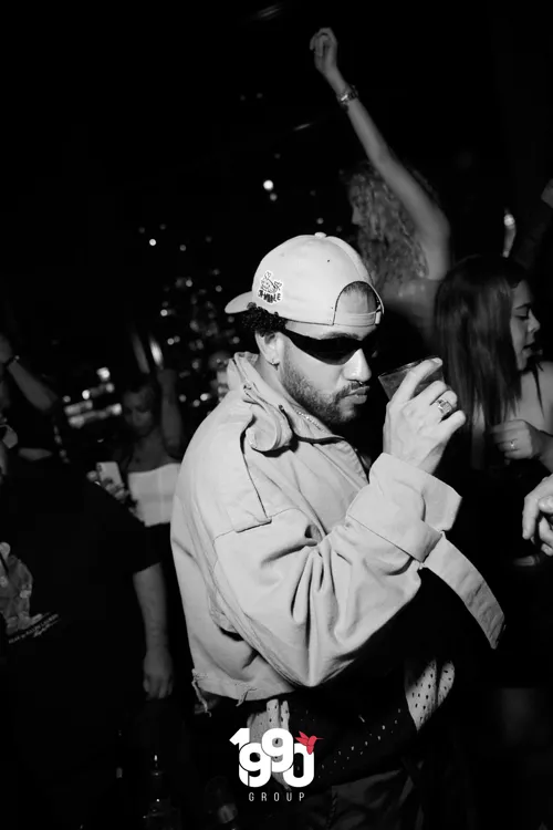 Man drinking and enjoying music at the Fuego Thursdays party organized by 1990 Group on a rooftop in New York.