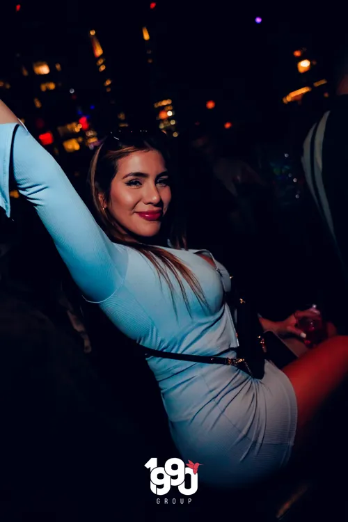 Woman posing with a smile at Fuego Thursdays, a party organized by 1990 Group in New York.